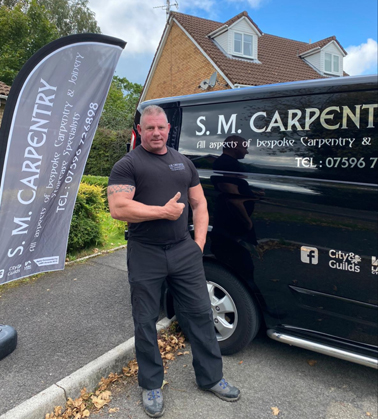 A carpenter alongside his van