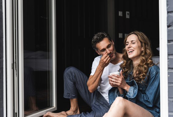 A man and a woman sitting next to bi-fold doors