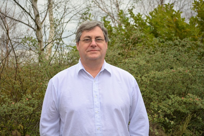 A man standing in front of trees