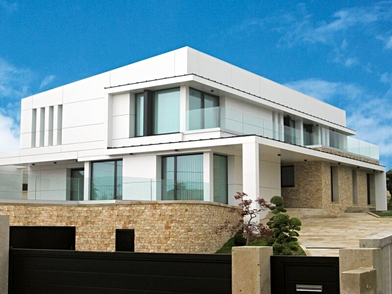 A white clad house with a glass balustrade