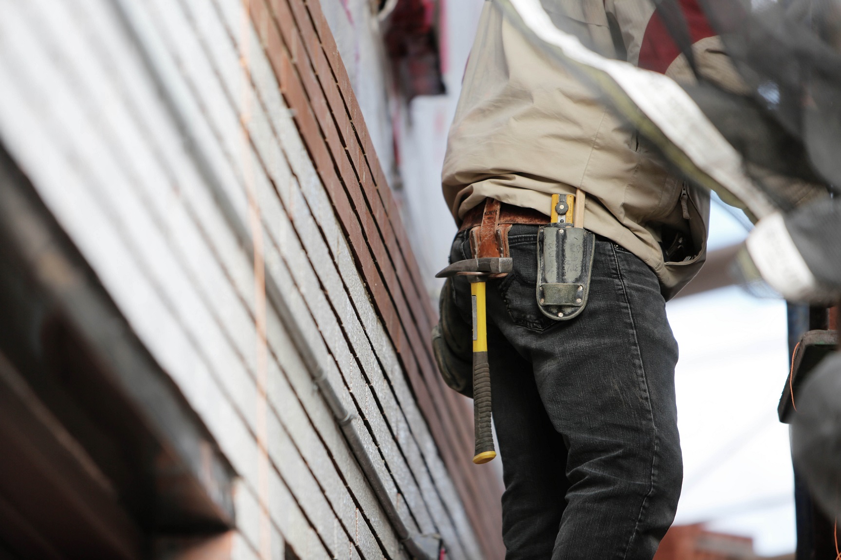 A construction worker at work with his tools on a toolbelt