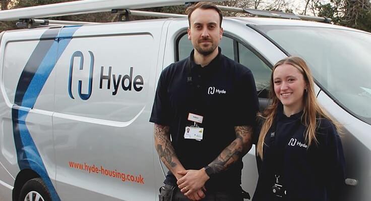 A man and woman standing by a commercial van