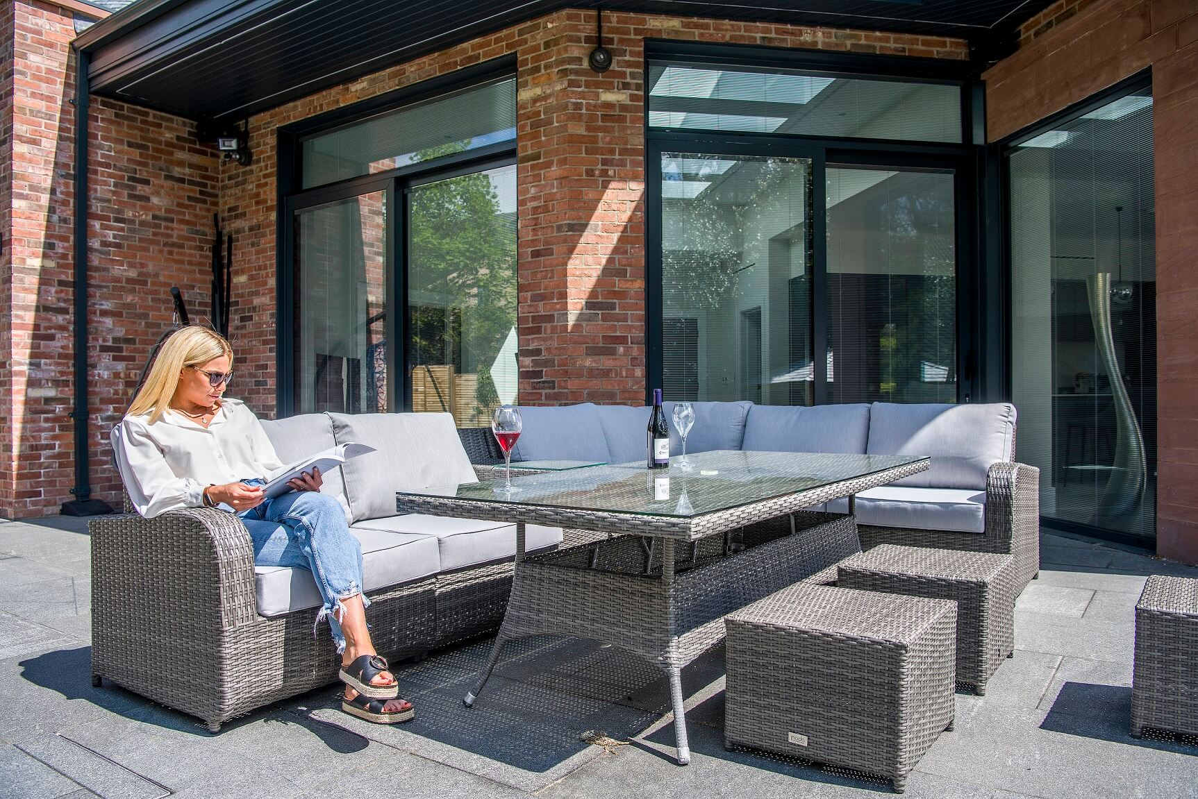 A woman sitting outside a building with integral blinds on the windows