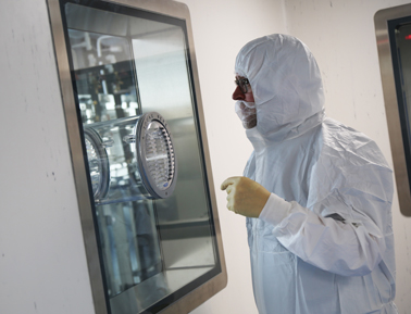 Man in protective suit at protective screen