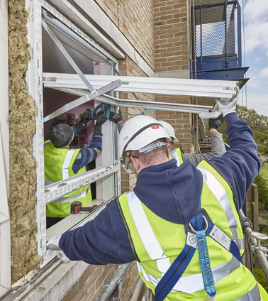 Men in high visibility vests installing windows