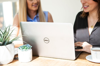 2 women sitting by a laptop