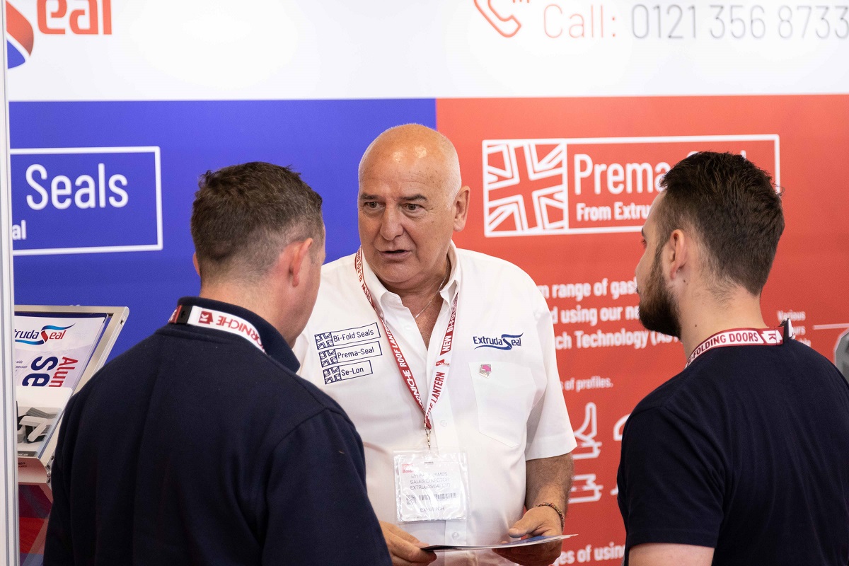 Three people talking at an exhibition