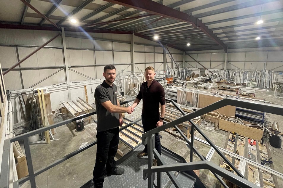 Two men in a factory shaking hands