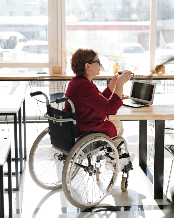 Woman sitting at a table in a wheelchair - Roto Zero Barrier