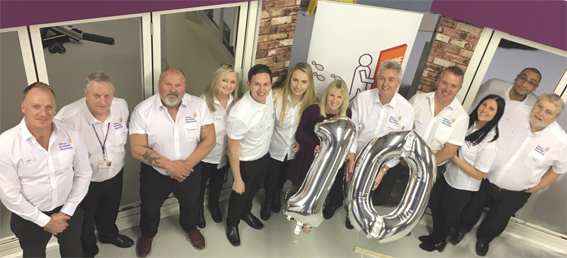 The Total Support Training team holding up silver helium balloons number 10